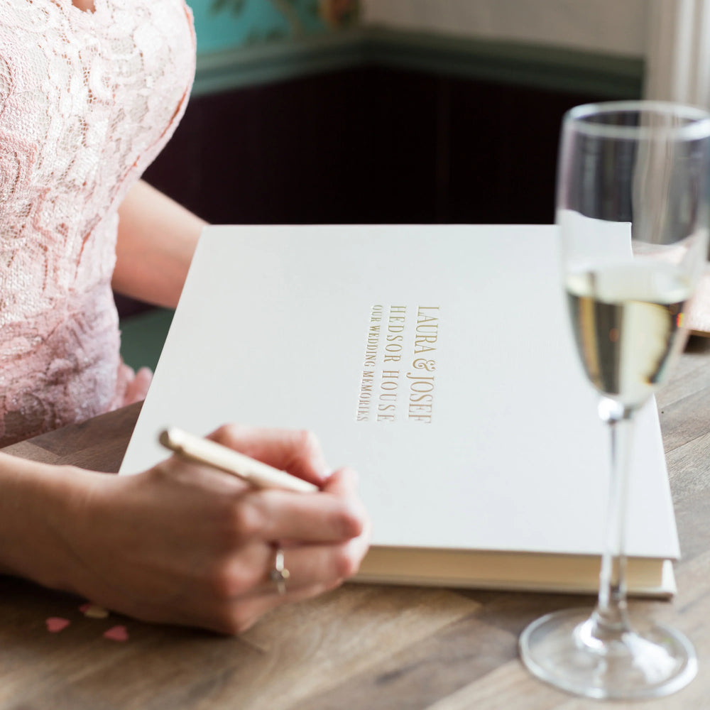 Woman about to write in beautifully personalised wedding guest book