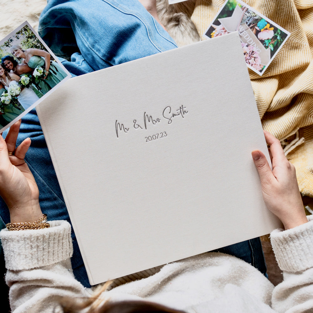 A lady about to start putting wedding photos into an ivory album