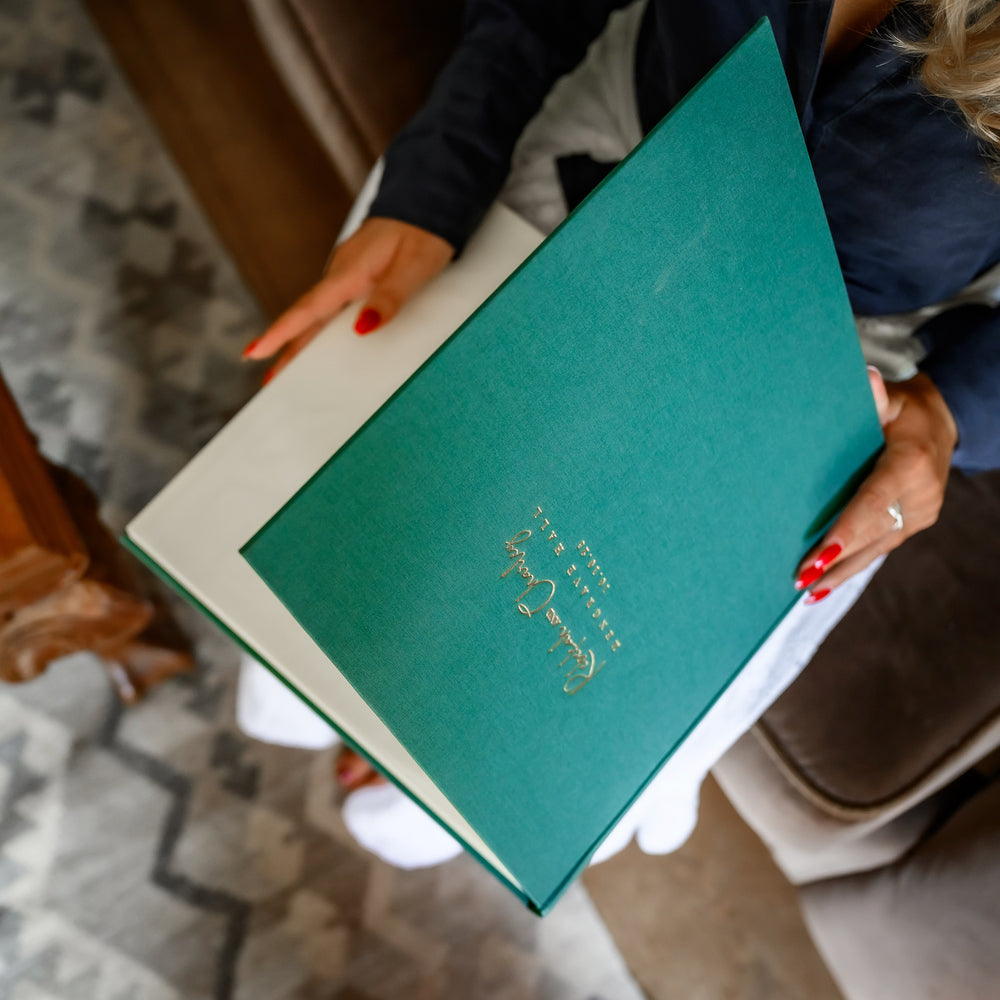 
                      
                        A lady looking though a beautiful emerald green album
                      
                    