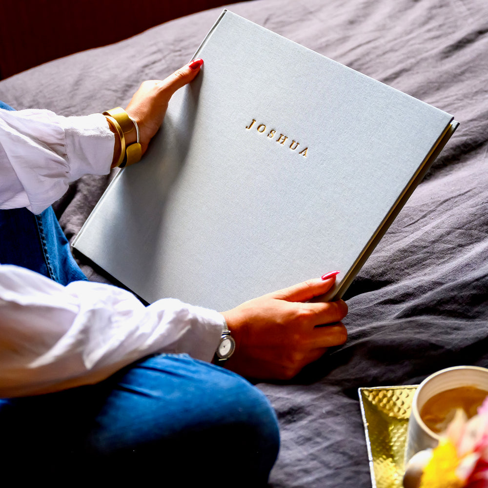 Large grey photo album with the name Joshua embossed on the front