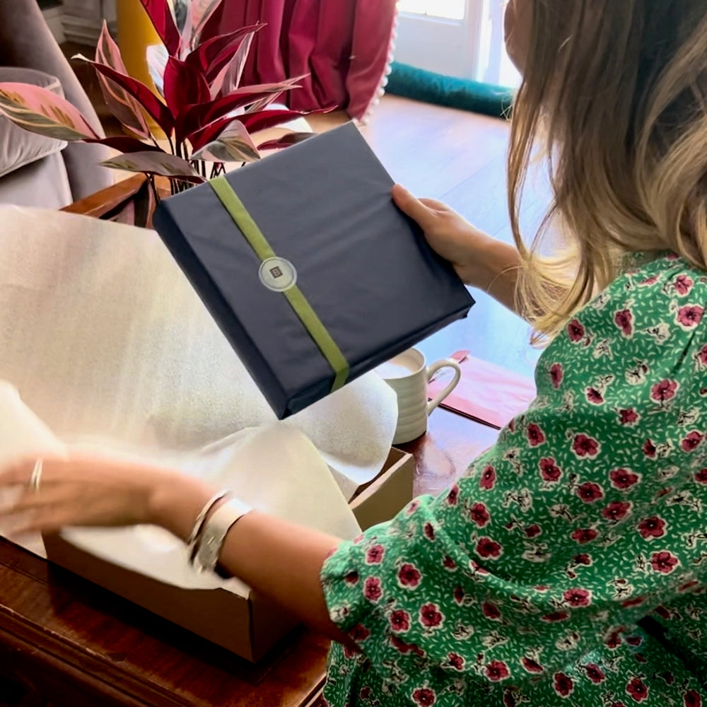 
                      
                        a woman holds a tissue wrapped photo album from BeGolden
                      
                    